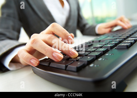 Macro image of human hand with forefinger going to press key on keyboard Stock Photo