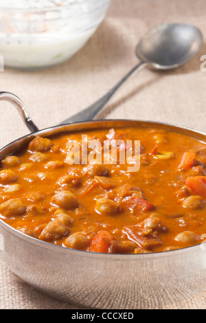 Chickpea Curry with raita in background Stock Photo