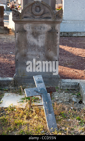 Broken crucifix on old grave, France Stock Photo