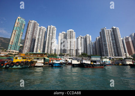 fishing boats and houseboats in aberdeen harbour in front of apartment blocks hong kong hksar china asia Stock Photo