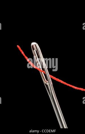 Sewing needle with red thread Stock Photo