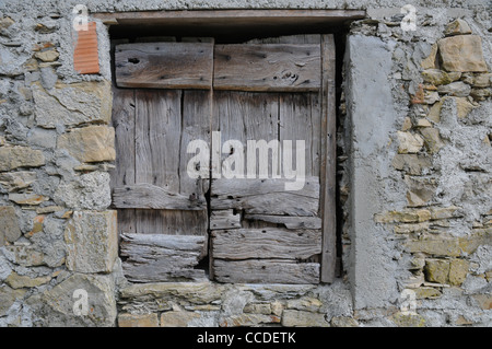 Weathered wooden window shutters rough stone brick wall Cisigliana, Tuscany Stock Photo
