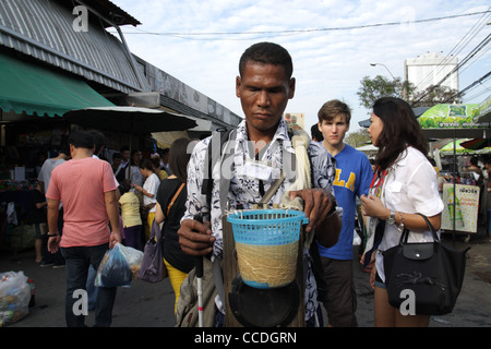 Blind beggar walking in Chatuchak Weekend Market , Bangkok Stock Photo