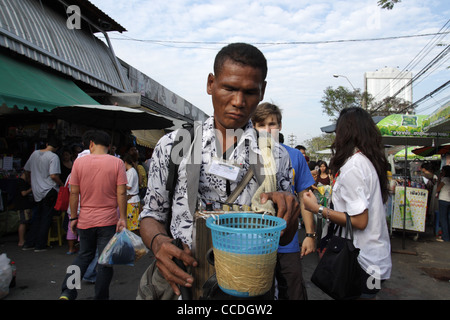 Blind beggar walking in Chatuchak Weekend Market , Bangkok Stock Photo