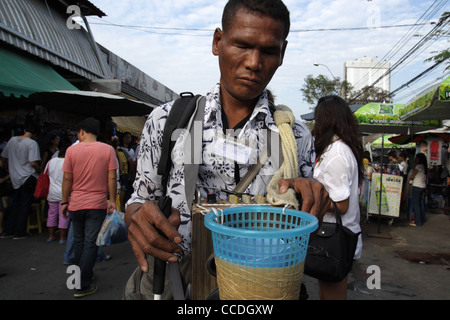 Blind beggar walking in Chatuchak Weekend Market , Bangkok Stock Photo