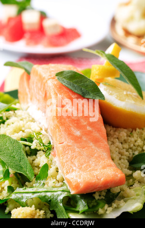 Salmon fillet and couscous garnished with fresh sage Stock Photo