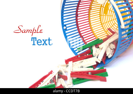 Multicolored clothes pegs in a basket on white background Stock Photo