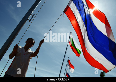 A man raises flags at the riverside in Phnom Penh, Cambodia Stock Photo