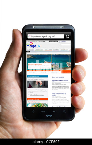 Looking at the Age UK charity website (an amalgamation of Age Concern and Help the Aged) viewed on an HTC smartphone Stock Photo