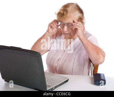 The old woman in glasses looks at the screen notebook on a white background Stock Photo