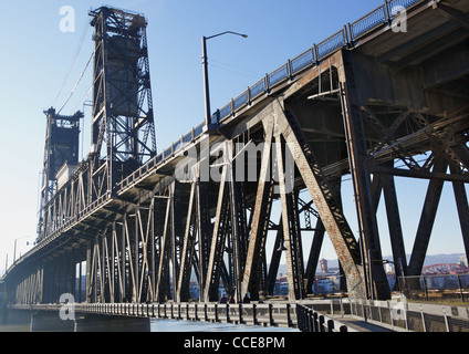 Old rusty steel bridge that carries rail and road traffic in Portland OR Stock Photo