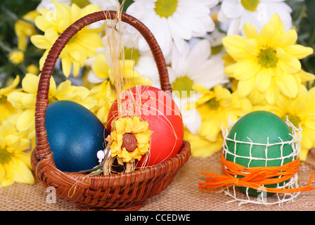 colorful eggs in wicker on flower background Stock Photo