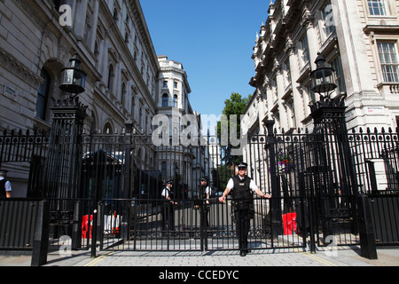 Armed Police guard the entrance to Downing Street, Westminster, London, England, U.K. Stock Photo