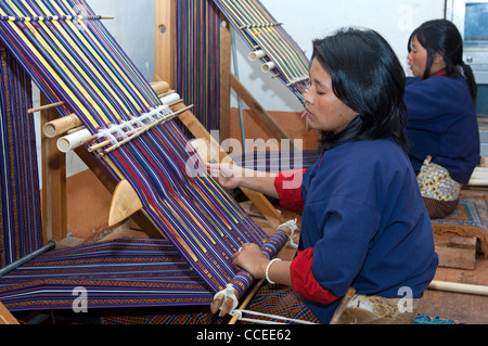 Young woman weaving at a traditional loom in the National Institute for Traditional Arts and Crafts, Thimphu, Bhutan Stock Photo