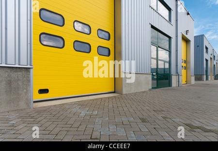 industrial warehouse with yellow and green roller doors Stock Photo