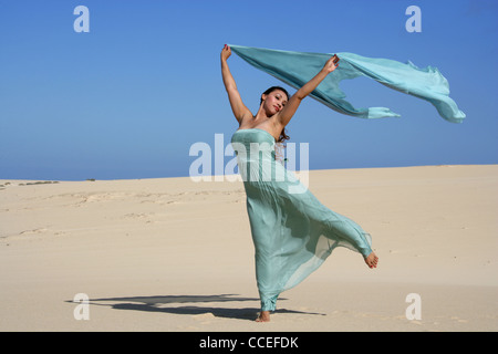 Indonesian Girl in a Turquoise Dress Posing on Sand Dunes, Fuerteventura, Canary Islands, Spain.