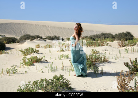 Indonesian Girl in a Turquoise Dress Running on Sand Dunes, Fuerteventura, Canary Islands, Spain.