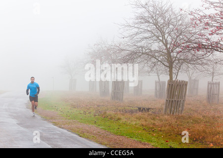 Running in Home Park, Hampton Court during a very foggy day. Stock Photo