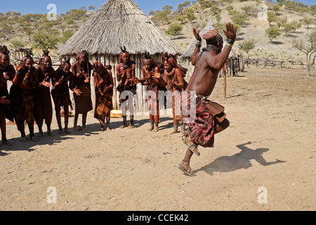 Himba women singing and man dancing in village near Opuwo, Namibia Stock Photo