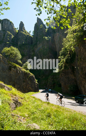 Two cyclist climb the hill through Cheddar Gorge on a very sunny day in the early summer. Stock Photo