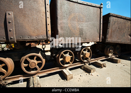 Mining cart with track rails on display at a roadside tourist stop in Moab Utah Stock Photo