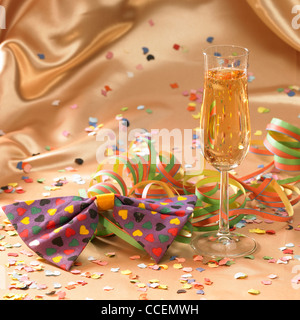 carnival background with filled champagne glass in floating satin back with streamers and confetti Stock Photo