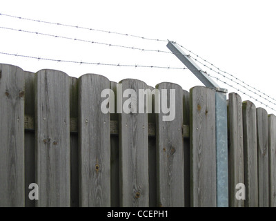 Wooden fence with barbed wire on top Stock Photo