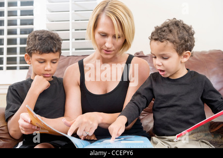 Mother reading book with two children Stock Photo