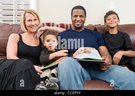 Portrait of happy family sitting on sofa Stock Photo