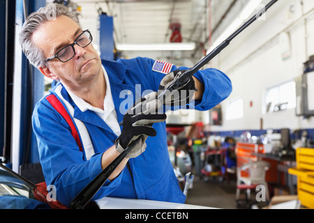 Mechanic working on windshield wipers of car Stock Photo