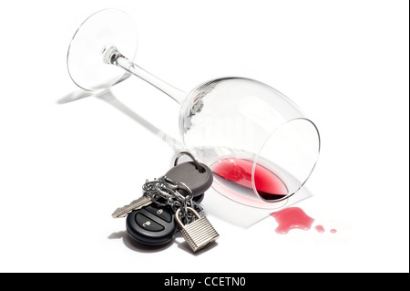 An knocked over glass of wine and a car key chained and padlocked Stock Photo