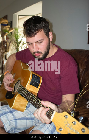 Young man playing guitar at home Stock Photo