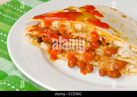 Chicken Quesadillas with Chili Beans, Sour Cream, Rice, Cheese, and Red and Green Hot Sauce Stock Photo