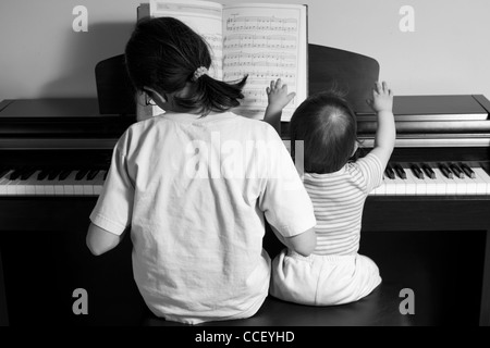 children playing piano (BW), back view Stock Photo