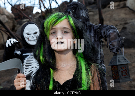 Portrait of girl dressed up as witch while her friends dressed up in skeleton costume Stock Photo