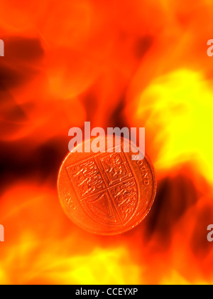 A one pound coin amongst flames Stock Photo