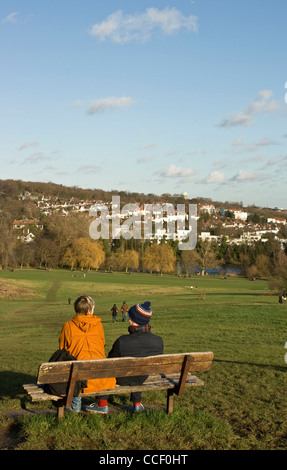 Man and woman relaxing in winter sun on Parliament Hill Hampstead Heath London England Europe Stock Photo