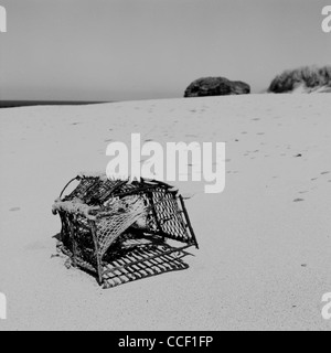 An empty lobster pot washed up on this remote empty sand beach near to Thurso on Scotlands North Coast. Stock Photo