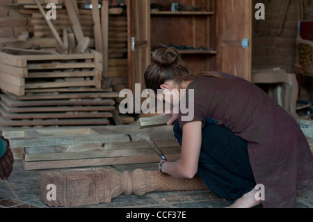 Young European woman learning wood carving at a workshop near Jaipur, Rajasthan, India Stock Photo