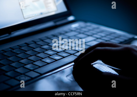Using a laptop, finger on touchpad and keyboard Stock Photo