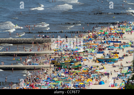 Middle of summer on the sandy beach of Niechorze. View from the lighthouse to the beach and fishing harbor. Stock Photo