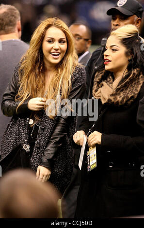 Dec 12, 2010 - NEW ORLEANS, LOUISIANA, USA - Singer and actress MILEY CYRUS with an unidentified friend on the sidelines before the New Orleans Saints play the St. Louis Rams during regular season play in New Orleans, Louisiana on December 12, 2010.  Cyrus is currently filming her new movie 'So Unde Stock Photo