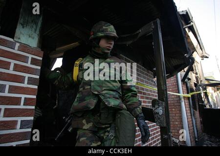 Nov 28, 2010 - Yeonpyeong Island, South Korea - South Korean marines search for a rocket dud in the broken village. Dozens of artillery shells fired by North Korea struck the island on November 23, resulting in four deaths and further injuries and prompting return fire from South Korean troops. (Cre Stock Photo