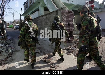 Nov 28, 2010 - Yeonpyeong Island, South Korea - South Korean marines search for a rocket dud in the broken village. Dozens of artillery shells fired by North Korea struck the island on November 23, resulting in four deaths and further injuries and prompting return fire from South Korean troops. (Cre Stock Photo