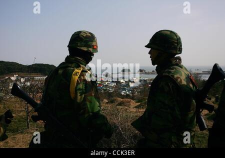 Nov 28, 2010 - Yeonpyeong Island, South Korea - South Korean marines search for a rocket dud in the broken village. Dozens of artillery shells fired by North Korea struck the island on November 23, resulting in four deaths and further injuries and prompting return fire from South Korean troops. (Cre Stock Photo