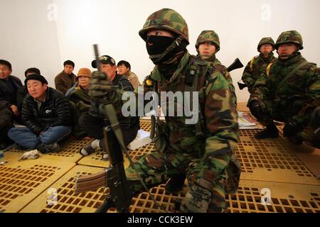 Nov 28, 2010 - Yeonpyeong Island, South Korea - South Korean marines take shelter in a bunker after siren and broadcast warnings go off. Dozens of artillery shells fired by North Korea struck the island on November 23, resulting in four deaths and further injuries and prompting return fire from Sout Stock Photo