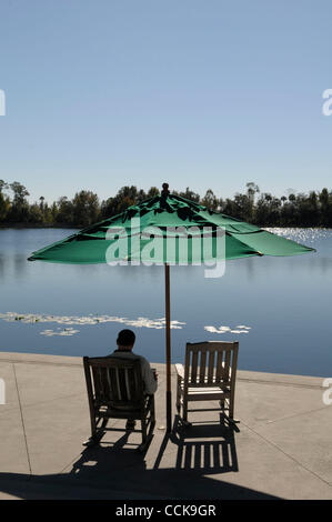 Dec 03, 2010 - Celebration, Florida, U.S. - A man reads along the banks of the lake in downtown Celebration, Fla., Friday, Dec. 3, 2010. This idyliic town that Disney built in 1996 has been shattered by its first murder, which happened sometime over the Thanksgiving weekend. Somebody killed Matteo P Stock Photo