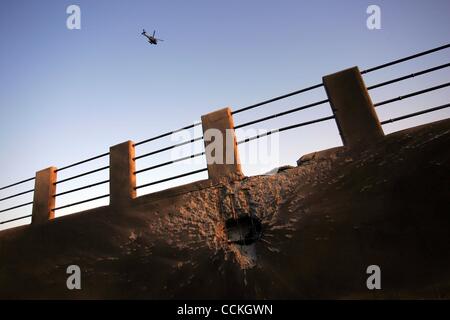 Nov 27, 2010 - Yeonpyeong Island, South Korea - A U.S. Army helicopter flies over a destroyed soccer field following an artillery exchange between North and South Korea. Dozens of artillery shells fired by North Korea struck the island on November 23, resulting in four deaths and further injuries an Stock Photo