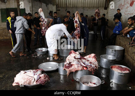 Nov 16, 2010 - Gaza City, Gaza Strip - Palestinian butchers slaughter a cow in a street on the first day of Eid al-Adha in Gaza City, Tuesday, Nov. 16, 2010. Muslims worldwide celebrate Eid al-Adha, or the Feast of the Sacrifice on Nov. 16, by sacrificial killing of sheep, goats, cows or camels. The Stock Photo