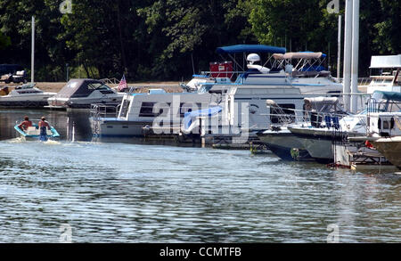 Jun 24, 2004 - Miami Township, Ohio, USA - ADDYSTON:  Boaters in a small runabout cruise past houseboats docked at Catalina Harbour. (Credit Image: © Ken Stewart/ZUMA Press) Stock Photo
